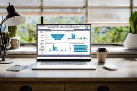 Thumbnail image of the Education Data Dashboard screenshot on a computer screen in an office with plants
